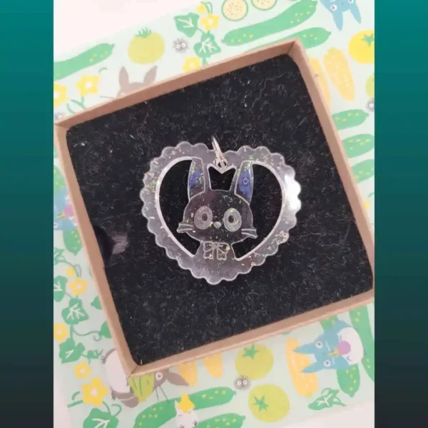 pendentif fait main en résine et fleur motif Jiji de Kiki la petite sorcière dans coeur